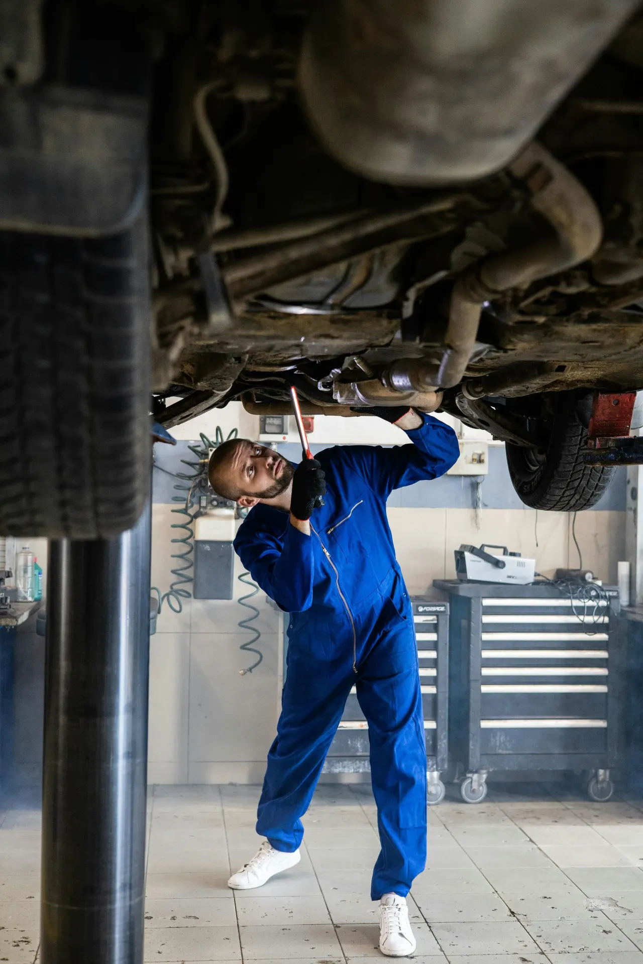 Lift üzerindeki aracın altında çalışan servis teknisyeni